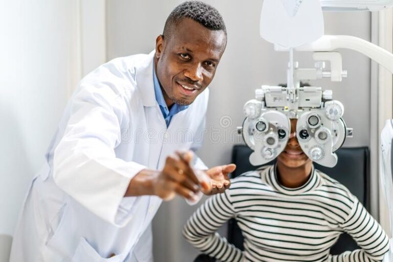 optician-doing-optometry-eye-exam-black-african-american-teen-girl-patient-male-optometrist-phoropter-examining-216111124